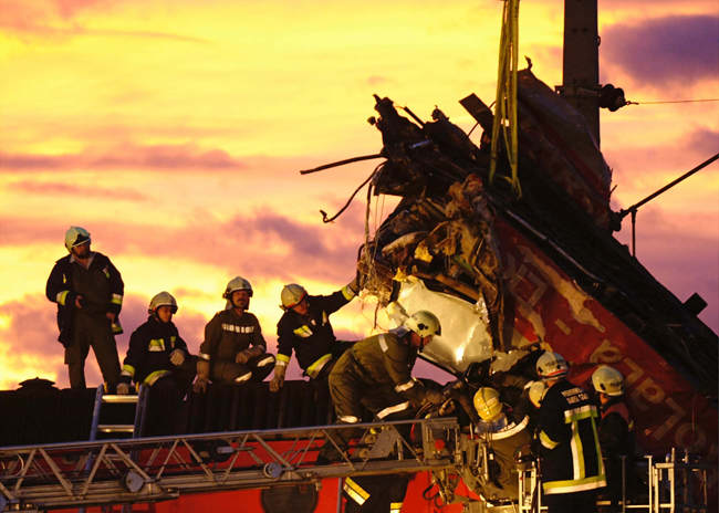 Feuerwehrleute auf den Wracks zweier frontal kollidierter Züge